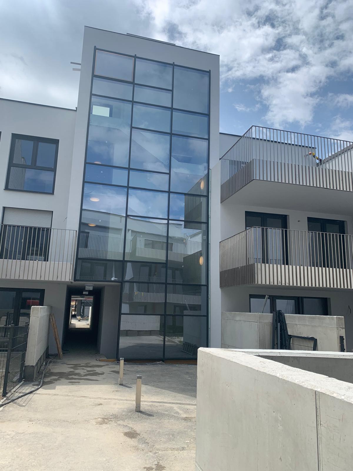Verglaste Stiegenhausfassade eines Mehrfamilienhauses, Fenster nach Maß