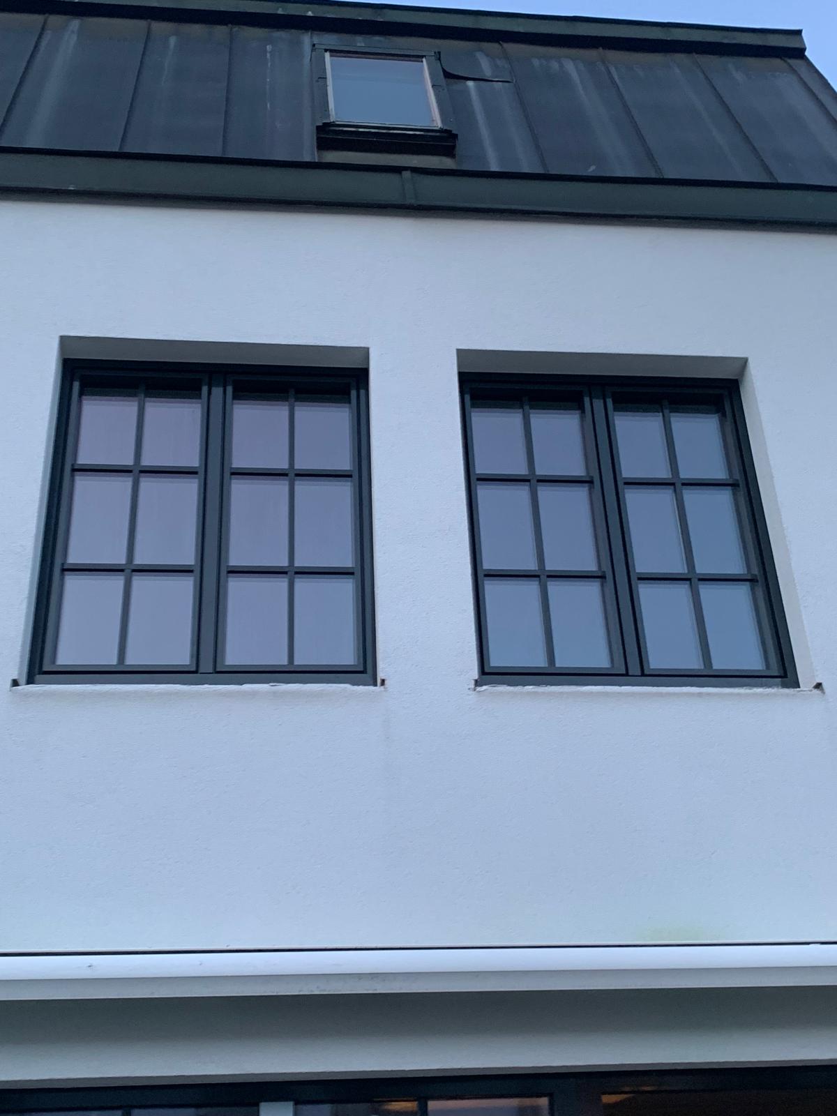 Sanierte Sprossenfenster in heller, frisch verputzter Altbaufassade