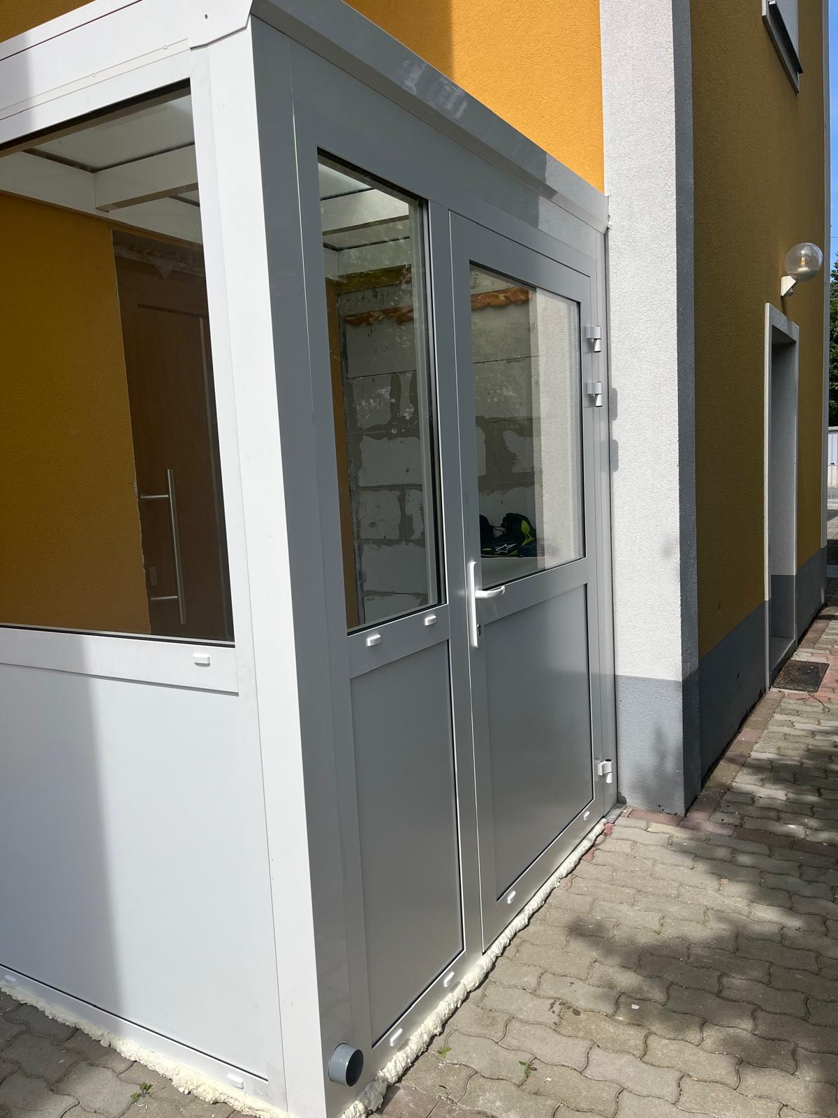 Grauer Aluminium-Windfang mit zweiflügeliger Sicherheits-Glastür