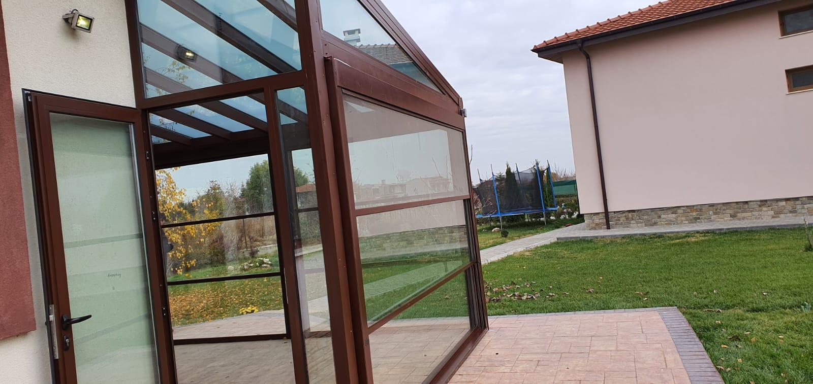 Wintergarten mit geöffneter Terrassentür und Blick in den Garten